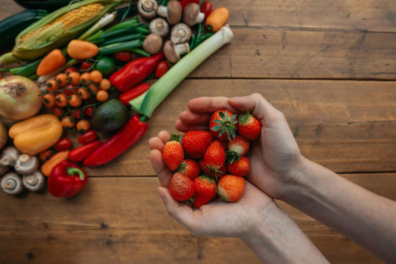Frische regionale Zutaten vom Bauernhof: bunte Zwiebeln, Eier im Weidenkorb und Weizenähren