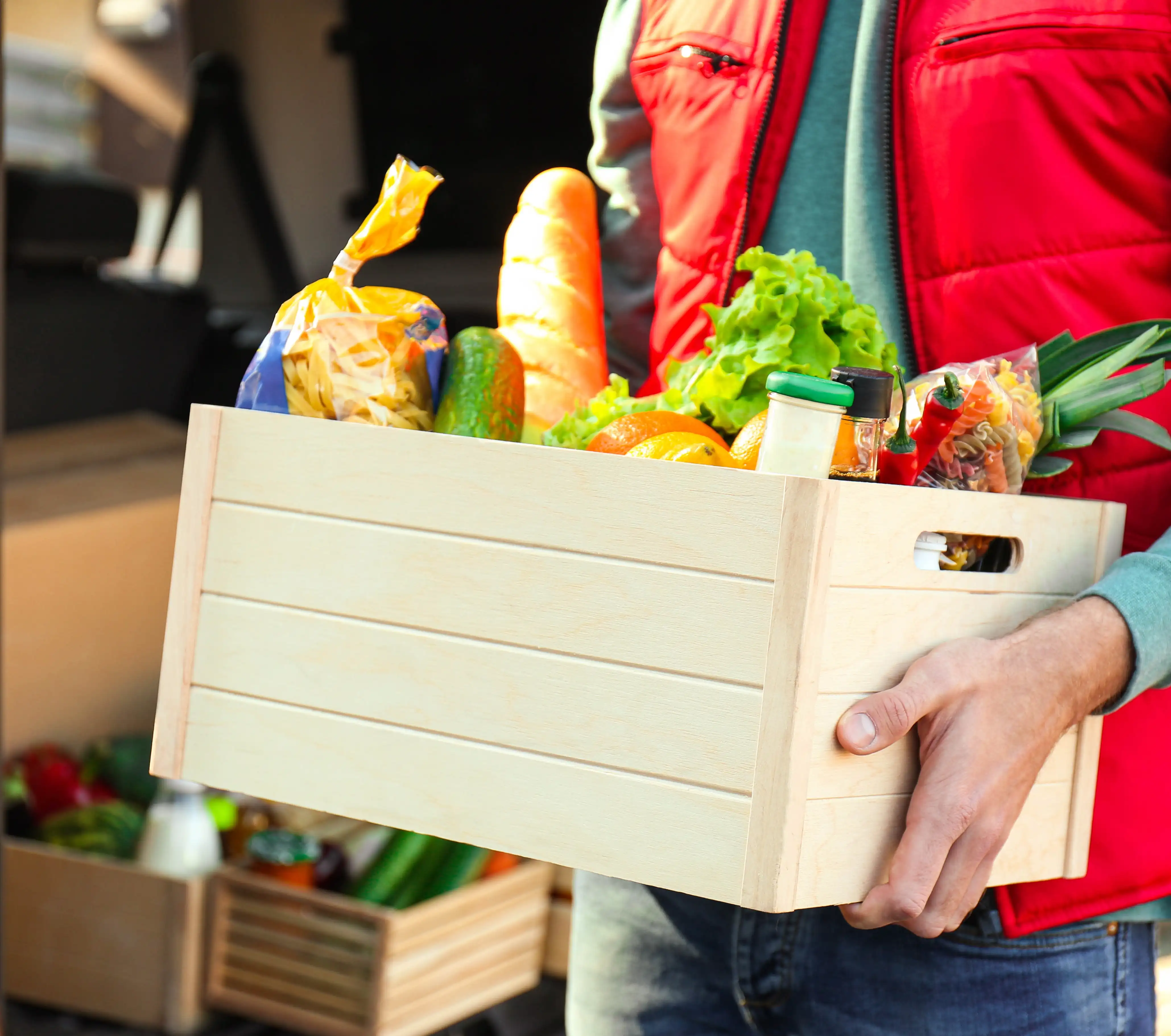 Lieferfahrer mit Einkäufen in der Hand bei auslieferung der Bestellungen